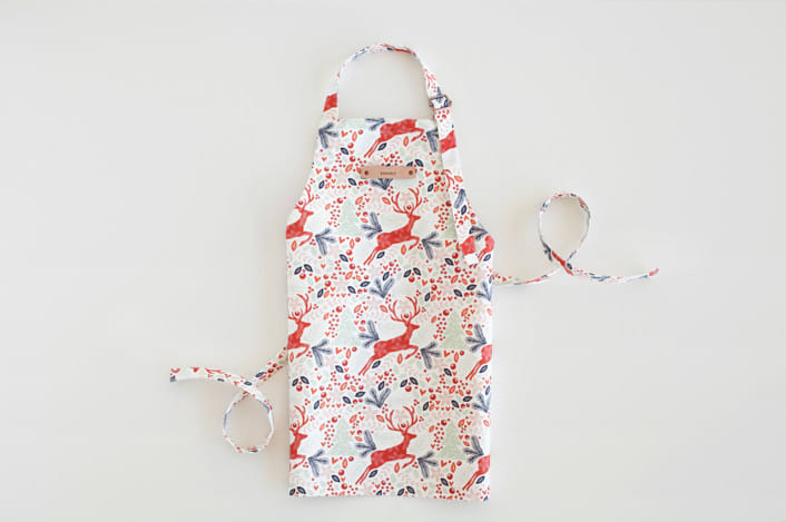 "Jumping Reindeer" - Personalizable Children's Apron in Red by Phrosné Barwood - Personalizable Apron