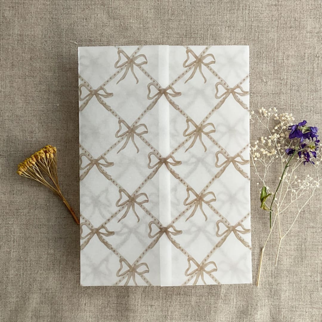 "Festive ribbon bow lattice hazelnut printed vellum wrap for 5x7 card | pack of 10" - Invitation Jackets and Overlays in beige by Ivory Invitations