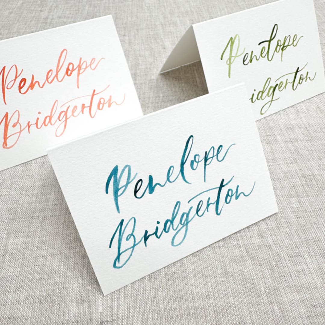 "Custom place cards with watercolor lettering | Tent place cards with modern calligraphy" - Place and Escort Cards in multicolorassorted-colors by Maria Ferrer G.