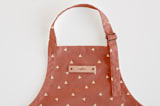 "Golden Triangle" - Personalizable Children's Apron in Rust by Cindy Lackey - Tag in Bodoni Regular