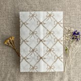 "Festive ribbon bow lattice hazelnut printed vellum wrap for 5x7 card | pack of 10" - Invitation Jackets and Overlays in beige by Ivory Invitations