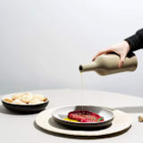 "Stoneware Olive Oil Dispenser | Brutto 21 oz" - Glassware in beige by Powered By People