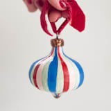"Red, Pink and Blue Striped Ornament with Red Ribbon" - Ornaments in multicolor by Mary Gaspar