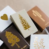 "Noble Fir Tree Matchbox, Gold on Sand" - Matchbooks and Matches in beige by Jessica Cunningham