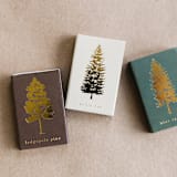 "Lodgepole Pine Tree Matchbox, Gold on Brown" - Matchbooks and Matches in brown by Jessica Cunningham