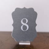 "Double Sided Table Number - Scroll - Dove" - Table Numbers in gray by Velvet Raptor