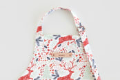 "Jumping Reindeer" - Personalizable Children's Apron in Red by Phrosné Barwood - Tag in Bodoni Regular