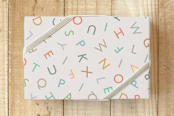 "ABC Letters" - Wrapping Paper in Rainbow Pastels by Carey Copeland - Front