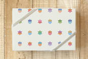 "Hanukkah Dreidels and Stars" - Wrapping Paper in Multi-color on Ivory by Carey Copeland - Front