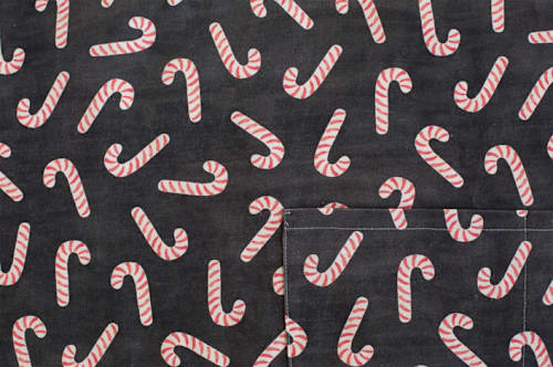 This is a black aprons by Hooray Creative called assorted candy canes in standard