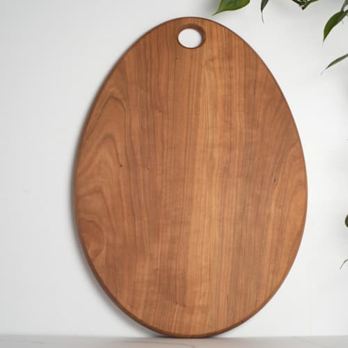 This is a yellow tableware by KHEM Studios called egg cutting & serving board cherry wood in standard
