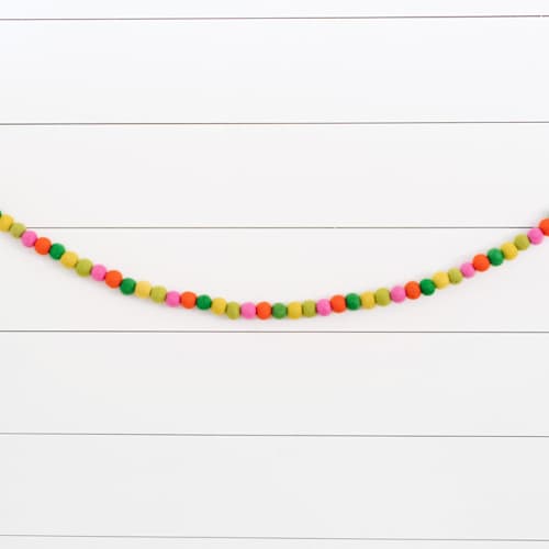 This is a multicolor holiday decorations by aubry bennion called oh what fun felt ball garland in standard