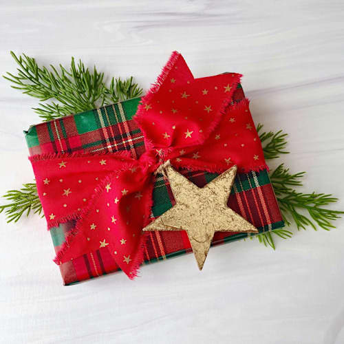 This is a red holiday decorations by Honey Silks Co called star cotton ribbon and gold leaf star set in standard