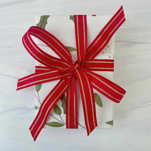 This is a red holiday decorations by Honey Silks Co called red and gold stripe holiday ribbon 5/8" x 15 feet in standard