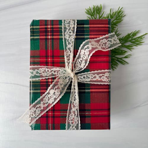 This is a white holiday decorations by Honey Silks Co called 1" x 4 yards holiday lace ribbon - antique white in standard