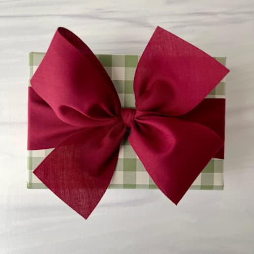 This is a red holiday decorations by Honey Silks Co called burgundy 2" x 15 ft holiday ribbon in standard