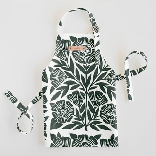 This is a dark teal kids aprons by Katharine Watson called block print floral in standard