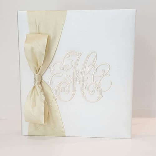 This is a white wedding gifts by Annie May called wedding memory book — ivory silk w/silk ribbon in standard
