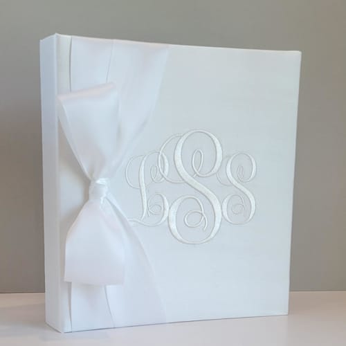 This is a white wedding gifts by Annie May called wedding memory book — white silk w/satin ribbon in standard