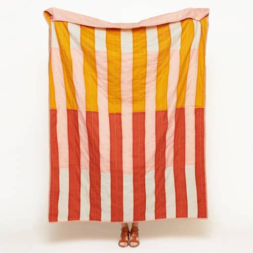 This is a pink throw blankets by Anchal called offset stripe quilt throw - rust in standard