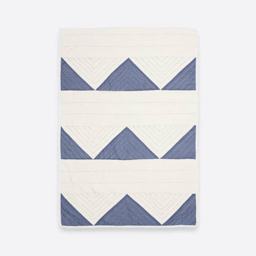This is a blue throw blankets by Anchal called small triangle quilt throw - slate in standard