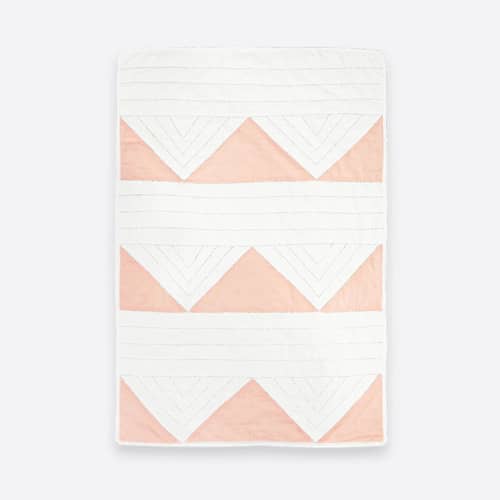 This is a pink throw blankets by Anchal called small triangle quilt throw - pink in standard