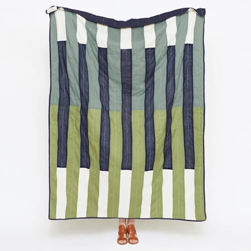 This is a green throw blankets by Anchal called offset stripe quilt throw - spruce in standard