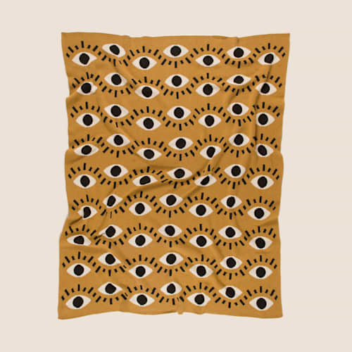 This is a gold throw blankets by Superstitchous called nazar eye throw blanket in standard