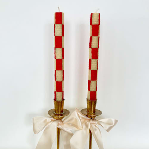 This is a red candles and candle holders by Annie Shapiro called checkered taper candles (red & beige) in standard