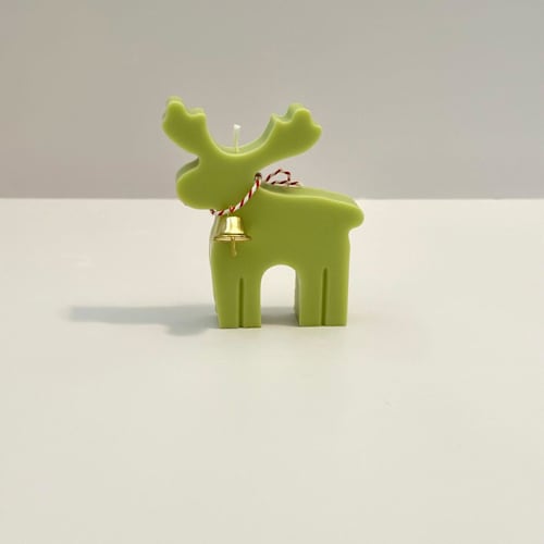 This is a green candles and candle holders by Over By The Moon called green reindeer candle in standard