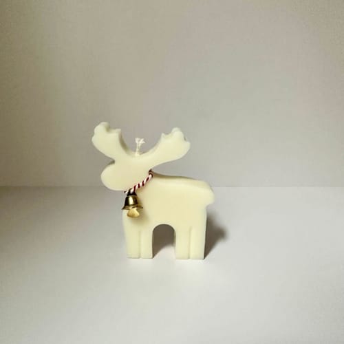 This is a white candles and candle holders by Over By The Moon called white reindeer candle in standard