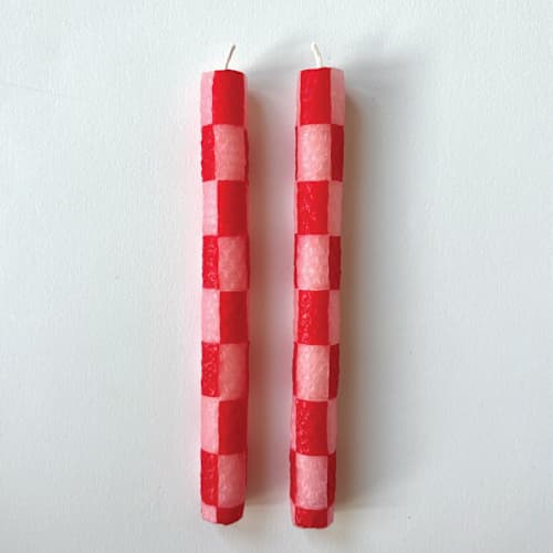 This is a pink candles and candle holders by Annie Shapiro called red and pink checkered candles in standard