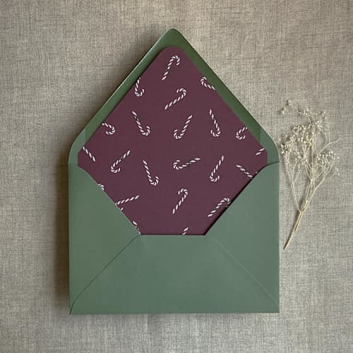 This is a purple wedding envelopes by Ivory Invitations called merlot holiday candy cane printed envelope liner for a7 euro flap envelope | pack of 10 in standard