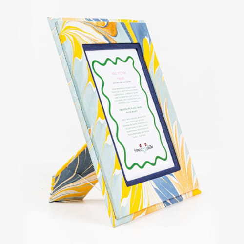 This is a blue accent pieces by Inner Child called hand-marbled picture frame in blue & gold, 4x6 in standard