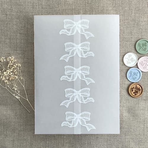This is a white vellum wedding invitations by Ivory Invitations called white ribbon bow printed vellum wrap for 5x7 card | pack of 10 in standard