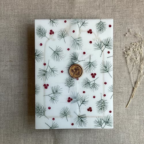 This is a green vellum wedding invitations by Ivory Invitations called holly berries green pine leaves printed vellum wrap for 5x7 card | pack of 10 in standard
