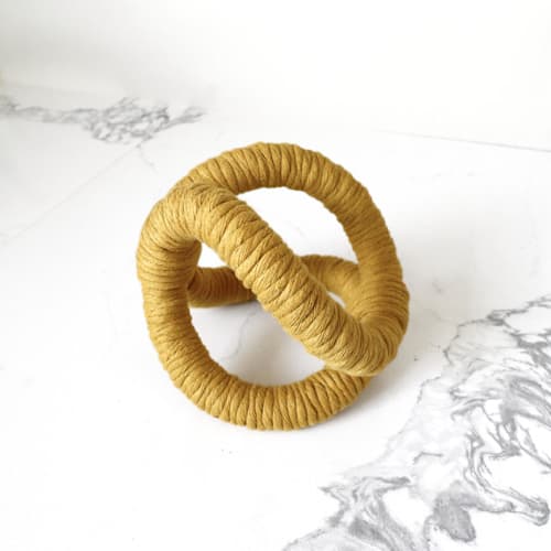 This is a yellow sculpture art by Bharti Trivedi called infinity loop in mustard in standard