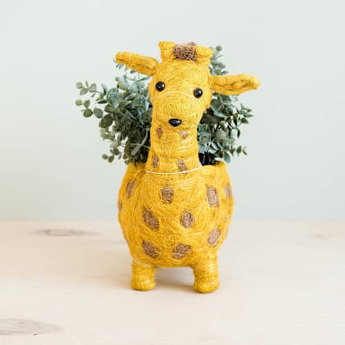 This is a yellow accent pieces by LIKHA called giraffe planter in standard