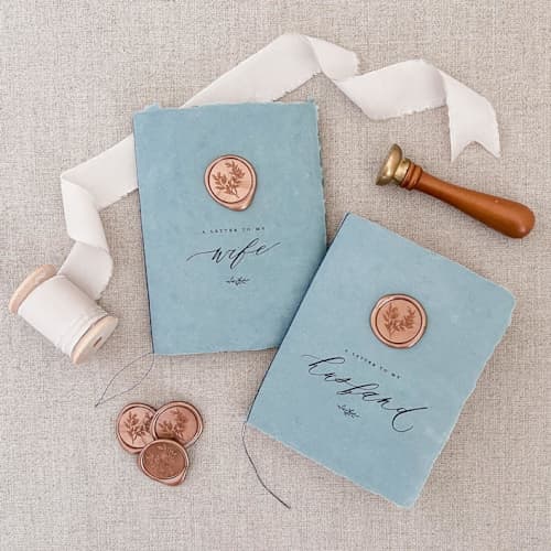 This is a blue vow books by Jen Simpson called wax seal his and hers vow book set - blue and rose gold in standard