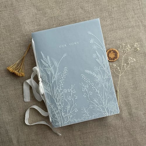 This is a blue vow books by Ivory Invitations called white ink print on vellum covered english botanical garden vow book | 1 book | our vows in standard