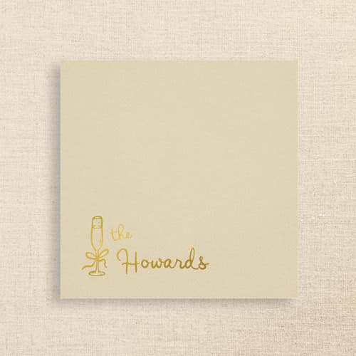This is a beige decorative paper napkins by Papel Custom Design called champagne linen-like napkin with personalized family name & champagne glass icon | pack of 50 in standard