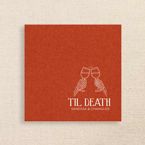 This is a orange decorative paper napkins by Papel Custom Design called “til death” terracotta linen-like napkin with skeleton toast design | pack of 50 in standard
