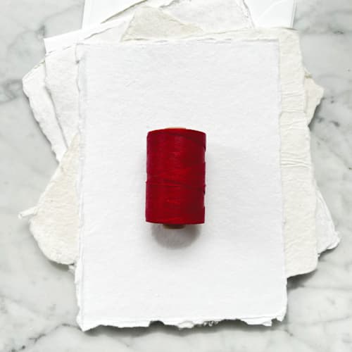This is a red wedding ribbon by Jenny Sanders called cherry red waxed linen twine, 2-ply in standard