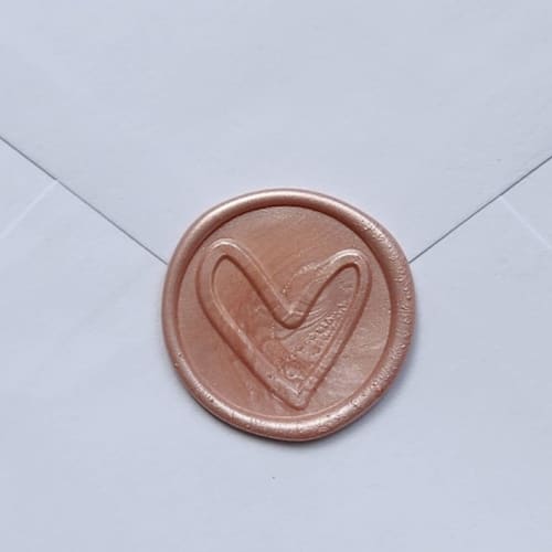This is a gold wax seals by MC silverlinings called customizable color heart self-adhesive wax seals, set of 5 in standard