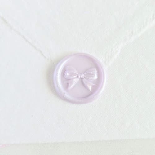 This is a multicolor wax seals by Inkspiringletters called mini bow- customizable color- set of 25 hand-crafted wax seals in standard