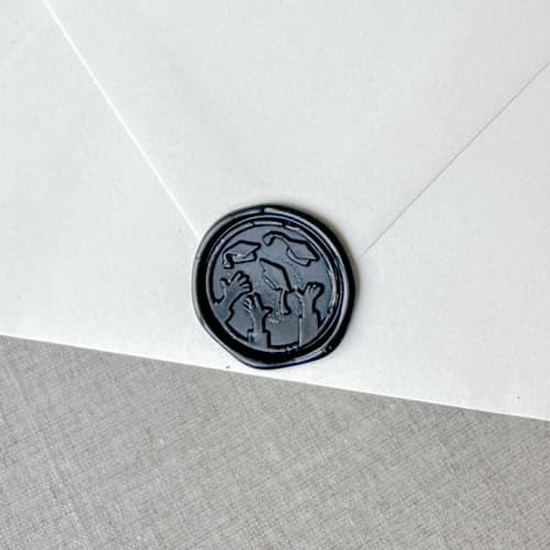 This is a black wax seals by Orchid Studio called black graduation wax seal - graduation cap throw | set of 10 in standard
