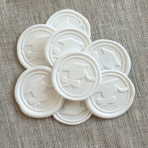This is a white wax seals by Orchid Studio called white graduation wax seal stickers - set of 10 in standard