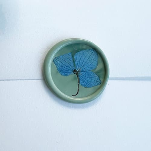 This is a green wax seals by Caitlin Home called blue hydrangea wax seal in celadon | pack of 10 in standard