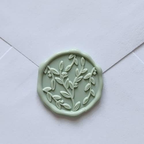 This is a green wax seals by MC silverlinings called customizable color vine leaves self-adhesive wax seals, set of 5 in standard