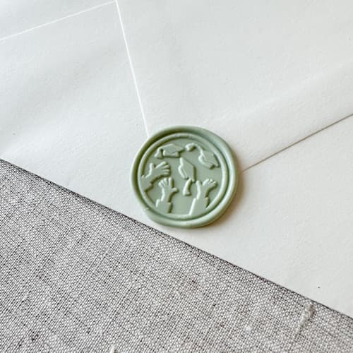 This is a green wax seals by Orchid Studio called sage green graduation wax seal - graduation cap throw | set of 10 in standard